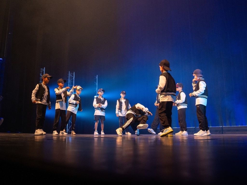 Kids-Gruppe von Boom Base bei einem Breakdance-Auftritt auf der Bühne