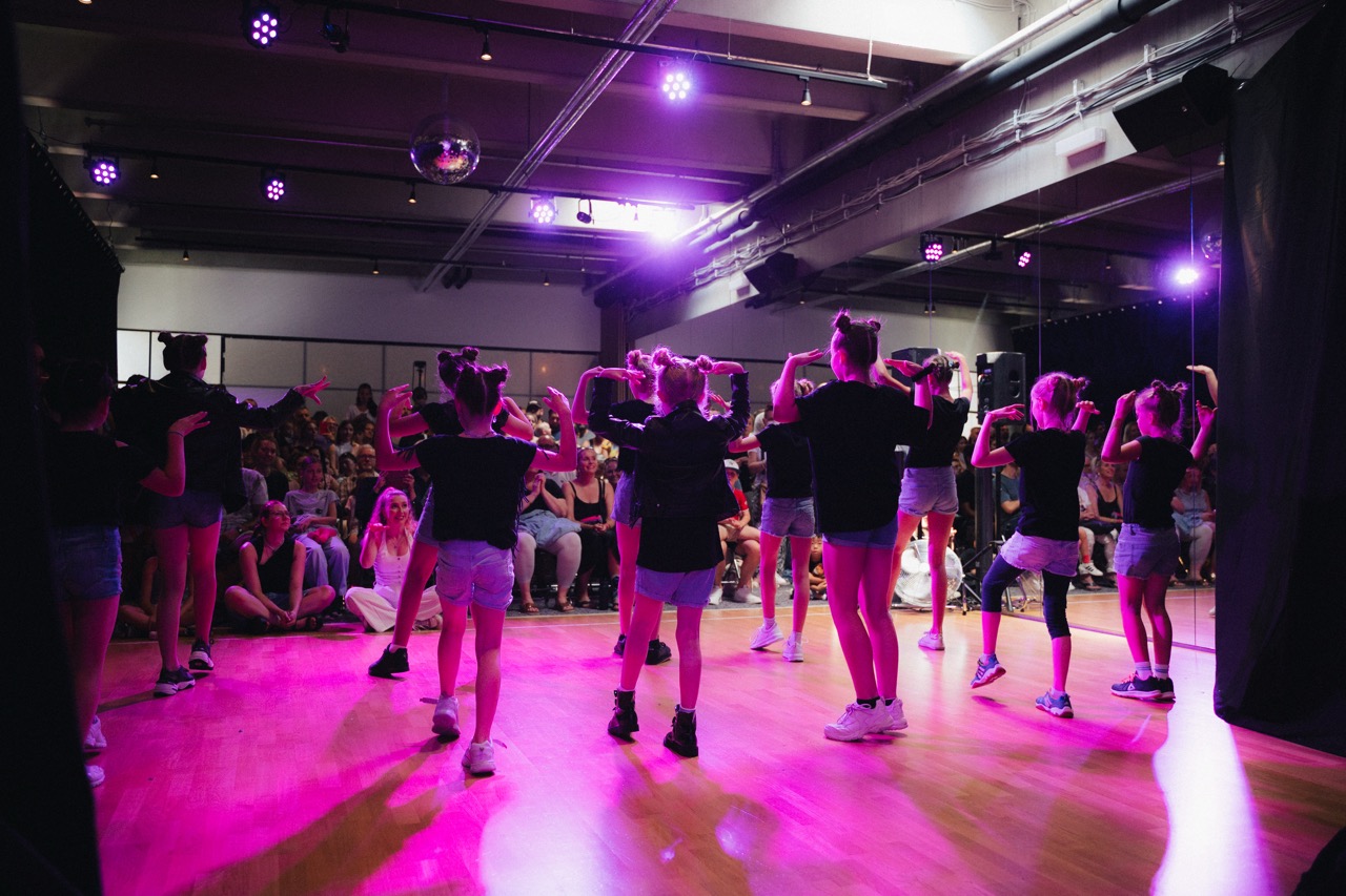 Kinder tanzen Commercial Dance bei Boom Base im pinken Scheinwerferlicht