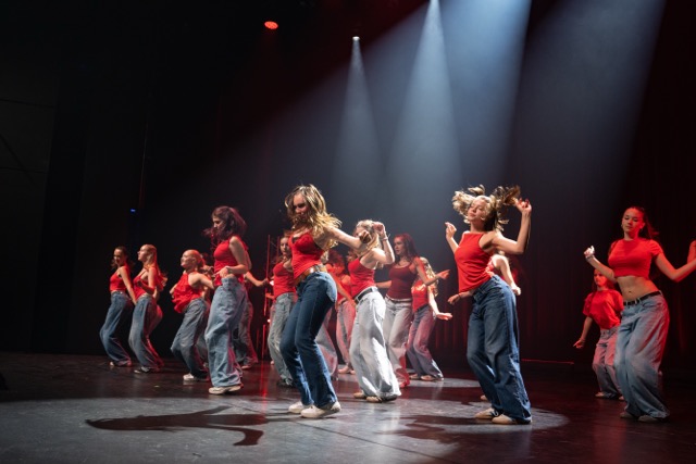 Teens tanzen Commercial Dance in roten Tops auf der Bühne